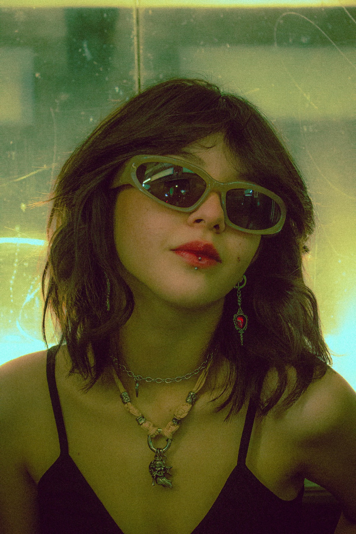 Alt portrait with stretched earlobes, facial piercings, and chain jewelry