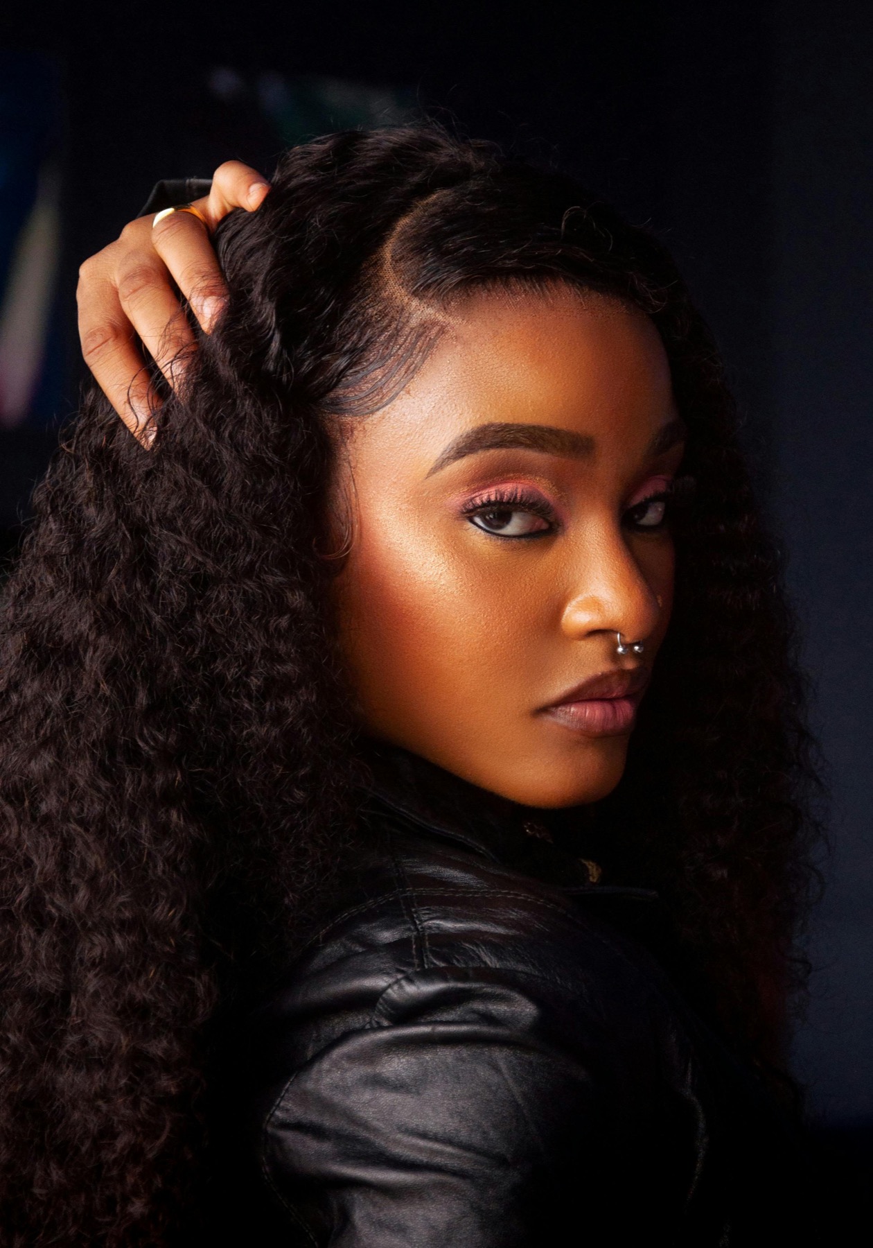 Portrait in a leather jacket with a visible septum piercing